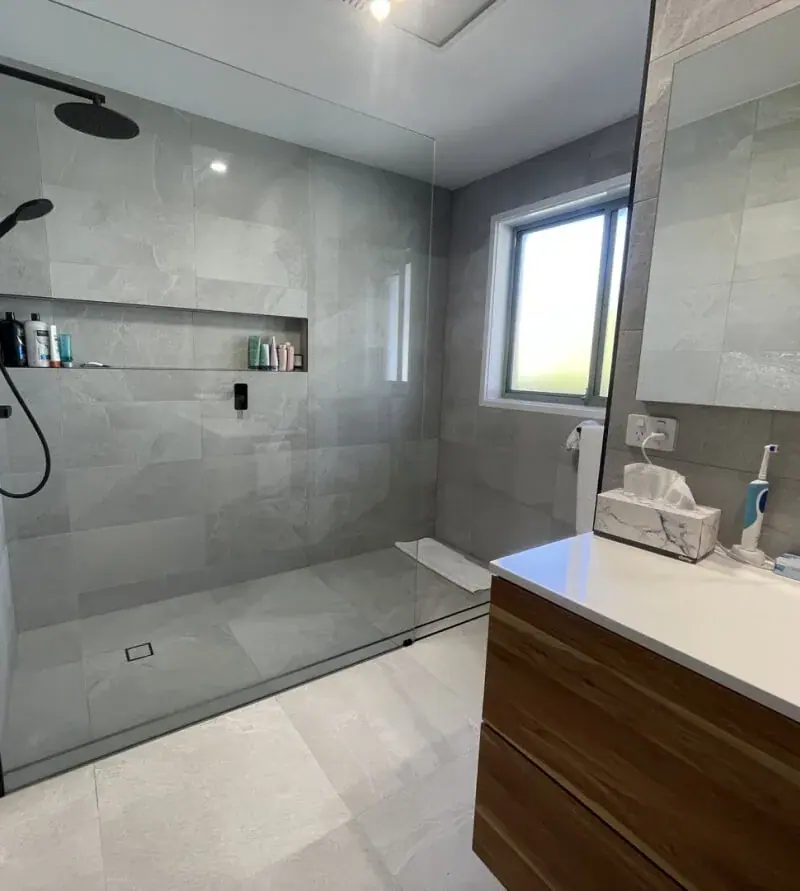 Renovated bathroom with floor-to-ceiling tiles and a walk-in shower, Canberra home