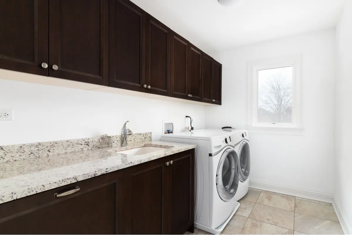 Laundry with a built-in trough, overhead storage and tiled splashback, Canberra home