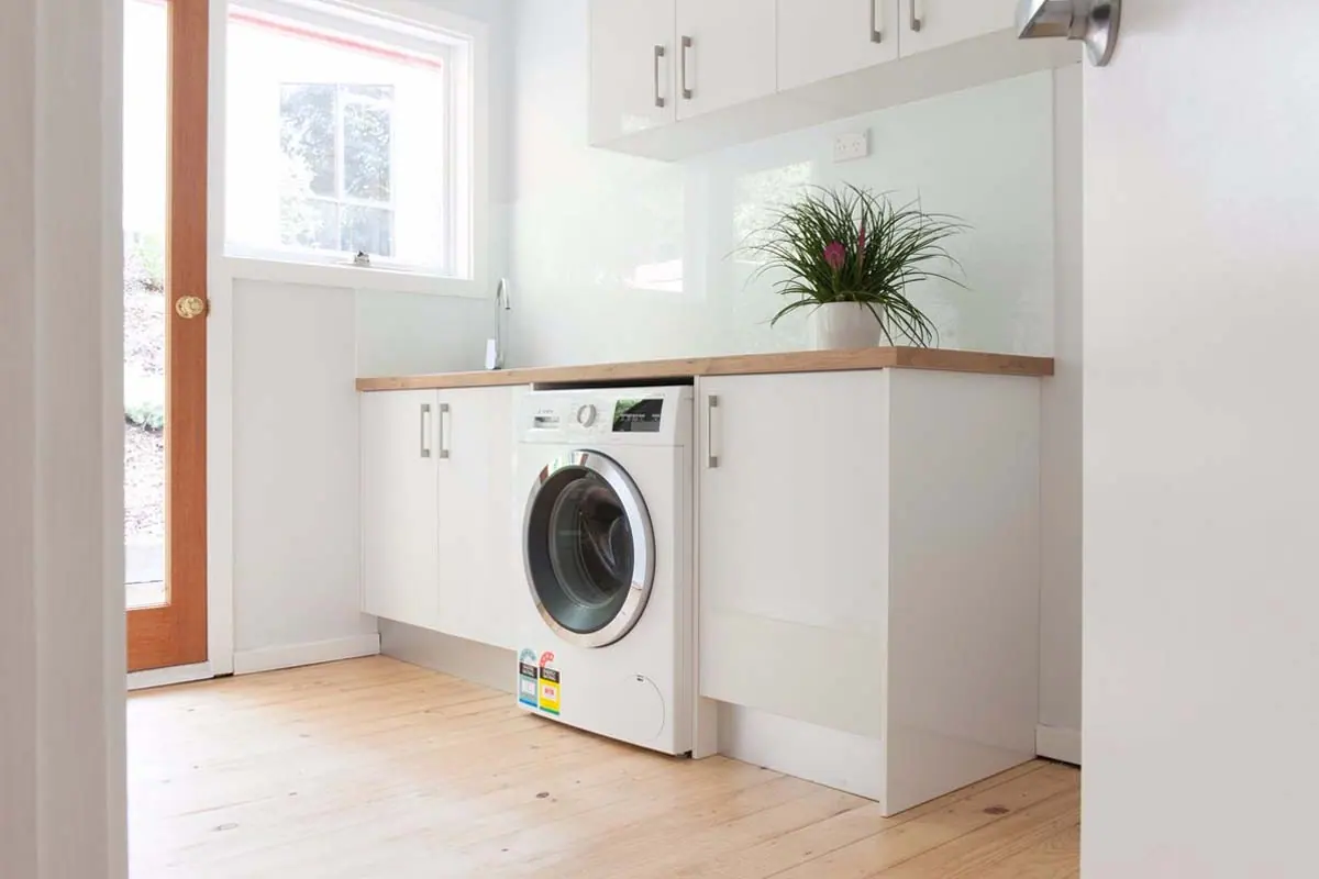 Tiled laundry floor and wall beside the appliance space, Canberra home