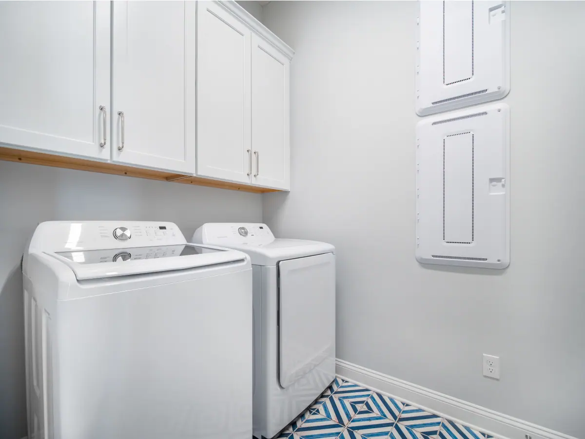 Renovated laundry with full-height cabinetry and a benchtop over the appliances, Canberra home