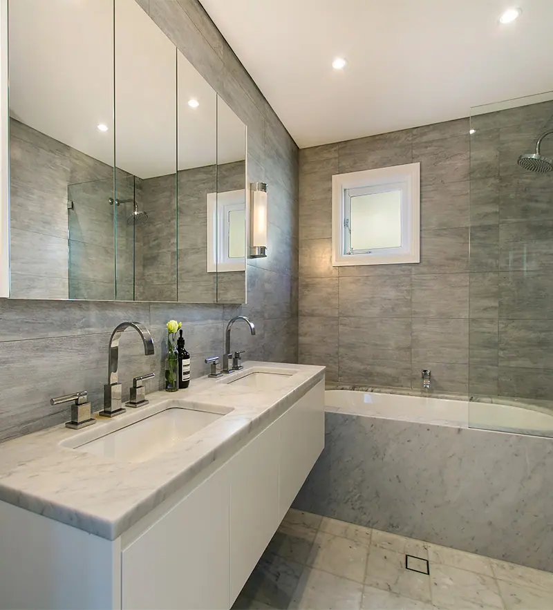 Small bathroom with floor-to-ceiling tiling and a clear glass screen, Canberra home