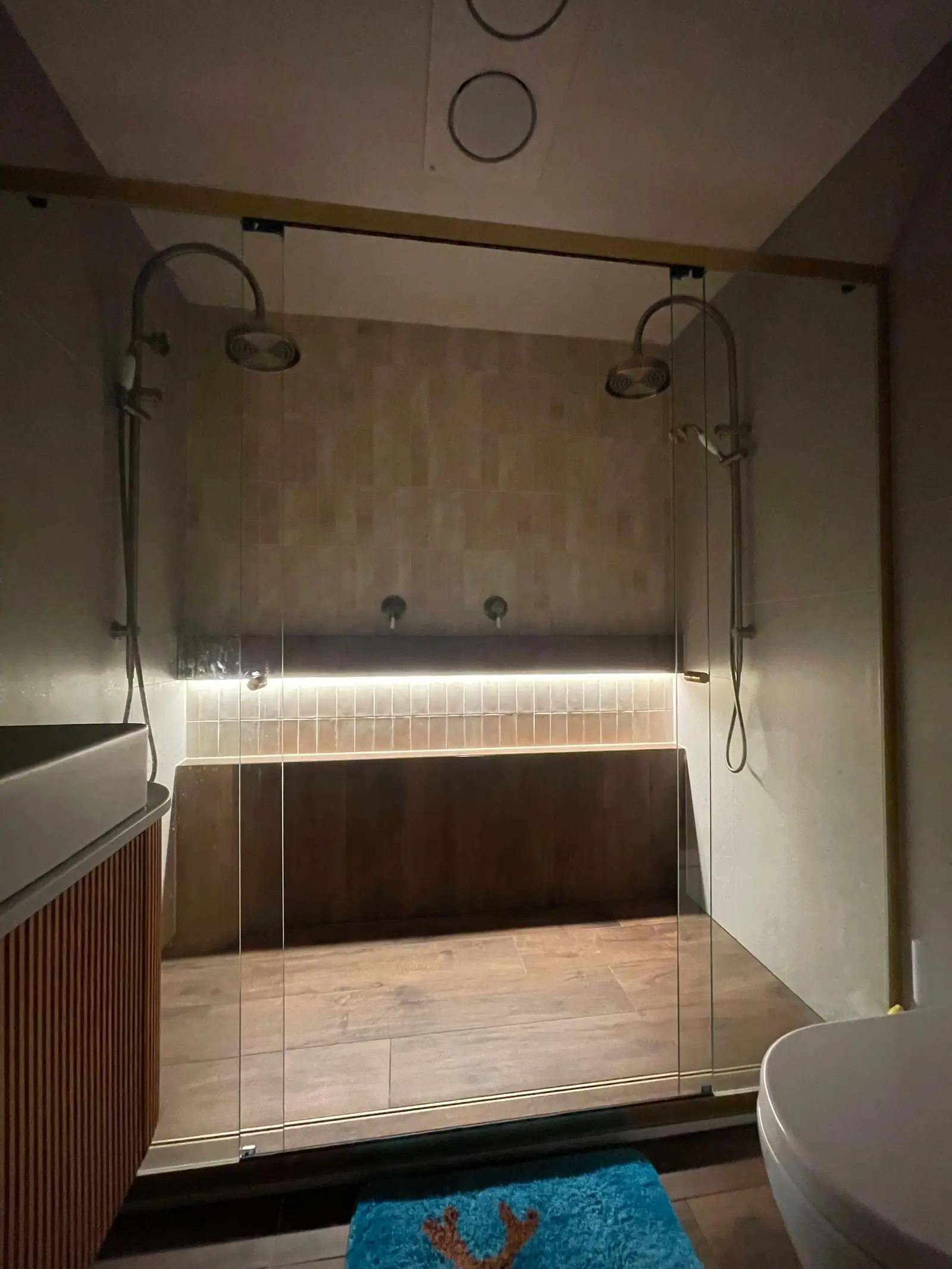 Double shower with a brushed-brass rail shower at each end and a lit tiled niche, Wanniassa home